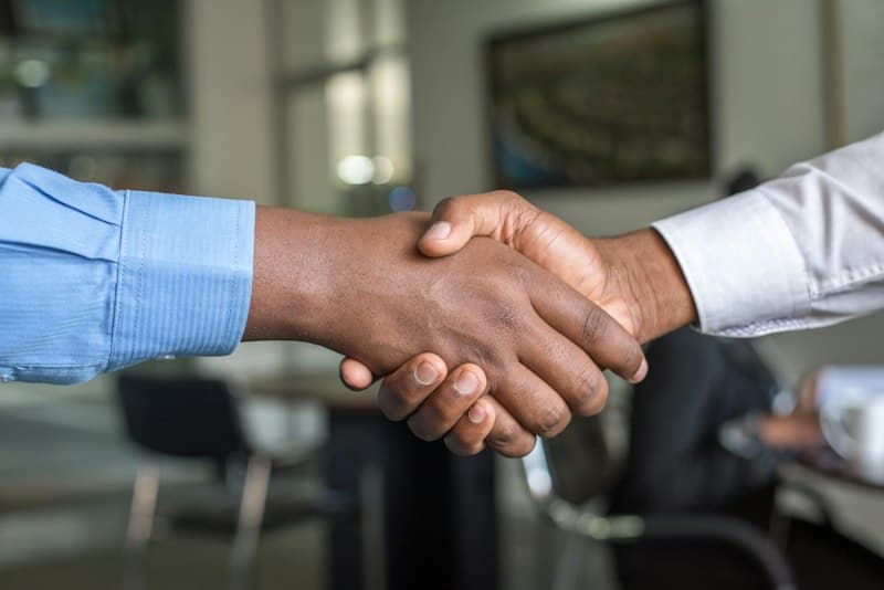 Commercial deal handshake representing partner program success